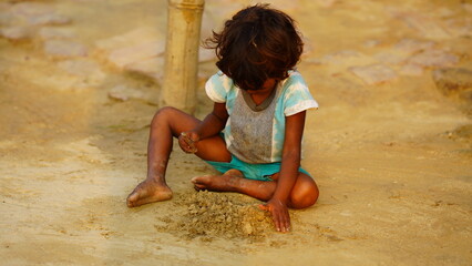poor alone baby girl playing in soil