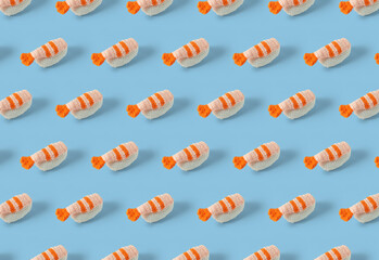 Nigiri sushi pattern crocheted with colored wool. Handmade crochet nigiri shrimp sushi on pastel blue background. Amigurumi sushi composition. Top view