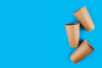 Disposable paper biodegradable cups on a blue background.