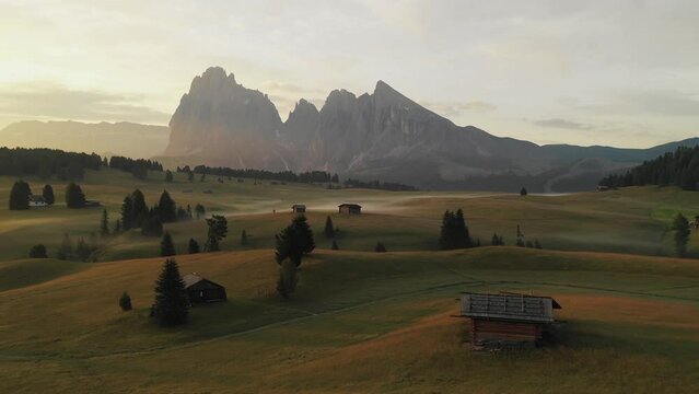 Aerial video of the sunrise in the Dolomites mountains. It was shot on the beautiful meadows of the Seiser Alm plateau with fog and mist in the morning.
