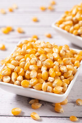 dry corn in small plate on wooden table