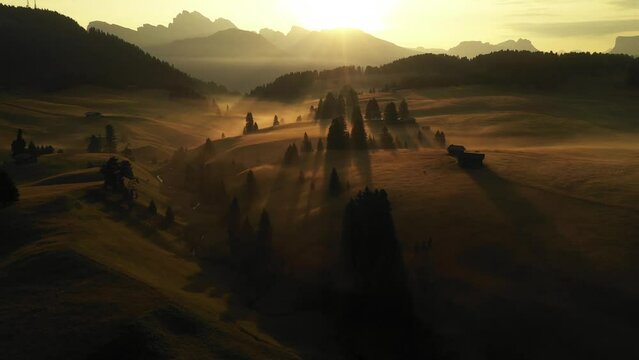 Aerial video of the sunrise in the Dolomites mountains. It was shot on the beautiful meadows of the Seiser Alm plateau with fog and mist in the morning.
