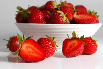 Red ripe strawberry in the white bowl, isolated