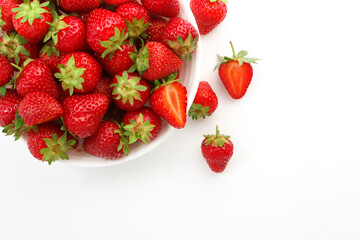 Red ripe strawberry in the white bowl, isolated