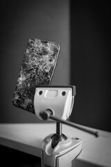 completely destroyed cell phone is clamped in a vice