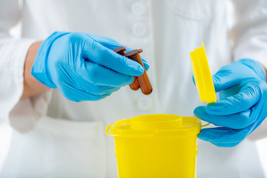 Medical Waste. Throwing Away Laboratory Consumables in Container for Hazardous Medical Waste.