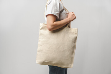 Cropped image of woman holding beige shopping bag in studio