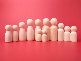 Wooden figures on a red background. Concept of family.
