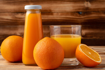 Obraz na płótnie Canvas Orange fruit and orange juice on wooden background