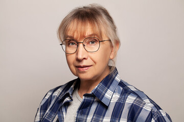 Attractive senior woman studio portrait while looking at camera and smiling