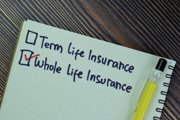 Concept of Whole Life Insurance write on a book isolated on Wooden Table.