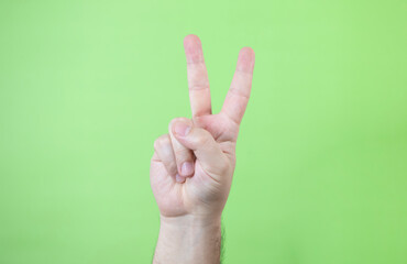 A man making hand signals on green background.