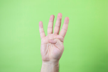 A man making hand signals on green background.