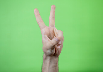 A man making hand signals on green background.