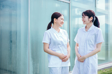 病院で働く白衣・ナース服を着たアジア人女性（屋上・2人）
