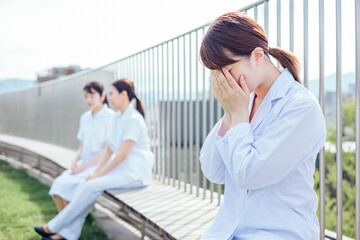 病院の屋上で泣く女性医師
