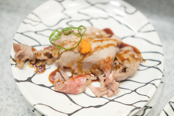 A dish of sliced and roasted Japanese beef sushi