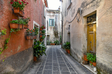A narrow street between the old houses of Teggiano, a medieval village in the mountains of Salerno province, Italy.