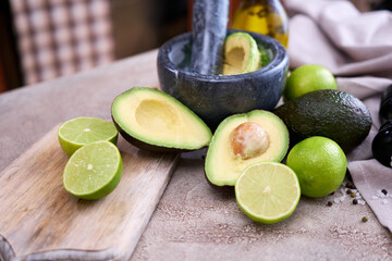 making guacamole - fresh sliced avocado in marble mortar on grey concrete table