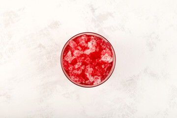 Slushie - drink with cherry. Sweet shaved ice in disposable plastic cup, top view