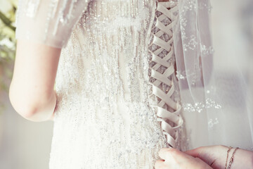 A close-up image of wedding preparations. lace up the corset of the bride
