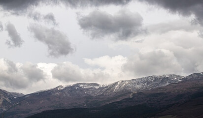 Snow-capped mountains against the background of the sky with clouds.