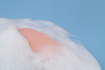Pink soap in foam bubbles close up. Copy space for text.