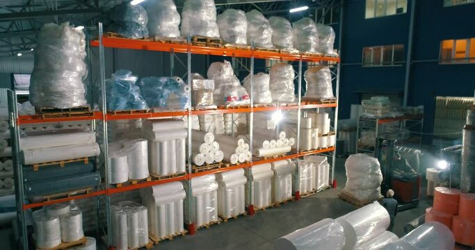Warehouse at the nonwovens factory. Flight to the warehouse of non-woven fabrics. Large modern warehouse with synthetic winterizer rolls