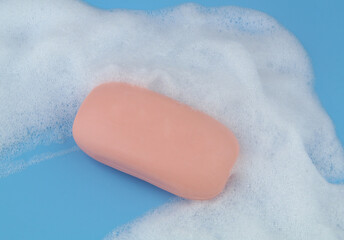 Soap bar and foam on blue background	