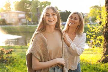 Happy mother with her daughter spending time together in park on sunny day