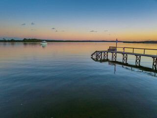 Obraz premium Sunset over the river with boat and wharf