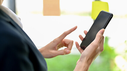Close-up image, A female hand holding a smartphone, typing on cellphone screen
