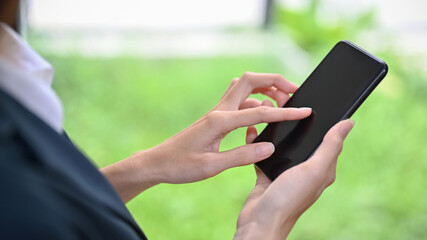 A female using modern smart mobile phone, touching on screen, scrolling on social media.