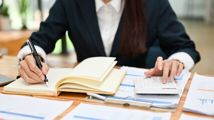 Businesswoman or financial assistant working at her desk, analysing financial data
