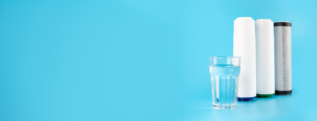 Banner set cartridges for water filter with clear glass of water isolated on blue background. ...