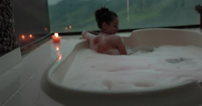 Beautiful woman alone in jacuzzi with flowers going up stairs - slow motion