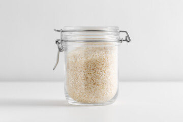 food, healthy eating and diet concept - jar with rice on white background