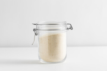 food, eating and cooking concept - jar with semolina on white background