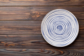 Fototapeta na wymiar Top view of empty colorful plate on wooden background. Empty space for your design