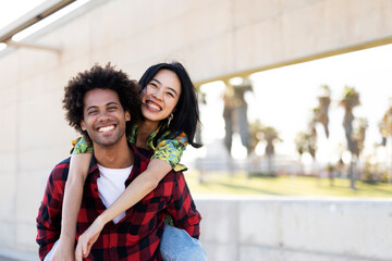 Beautiful young couple in love walking at the city street. Happy couple having fun outside.