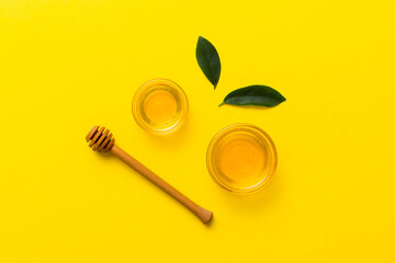 Honey jar with wooden honey dipper on white background top view with copy space. Delicious honey bottle