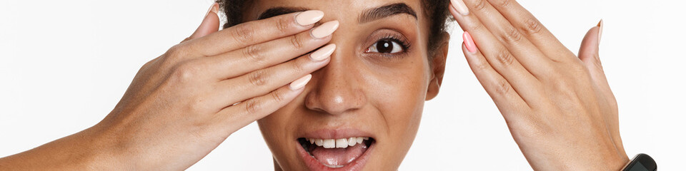 Young black woman in tank top smiling and covering her eye