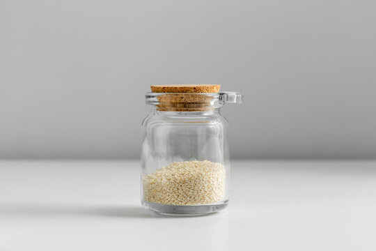 food, healthy eating and diet concept - jar with sesame seeds on white background