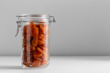 food, healthy eating and diet concept - jar with dried apricot on white background