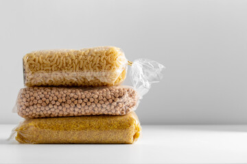 food, healthy eating and diet concept - bags with dried peas, pasta and bulgur on white background