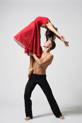 young couple of modern ballet dancers posing on clear studio background - 511011363