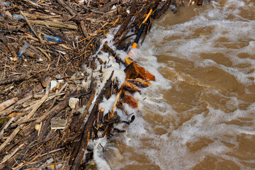 Pile of wood debris and plastic garbage during a flood, environmental water pollution