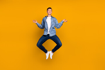 Fototapeta na wymiar Photo of young man jump up meditate practicing relax dreamy fresh energy isolated over yellow color background