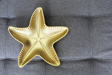 a plate in the shape of a golden star has a place for an inscription