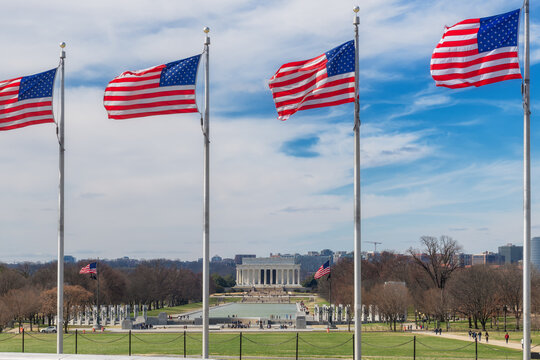 Lincoln Memorial with American flags from Washington Monument in Washington DC at sunny day, USA.